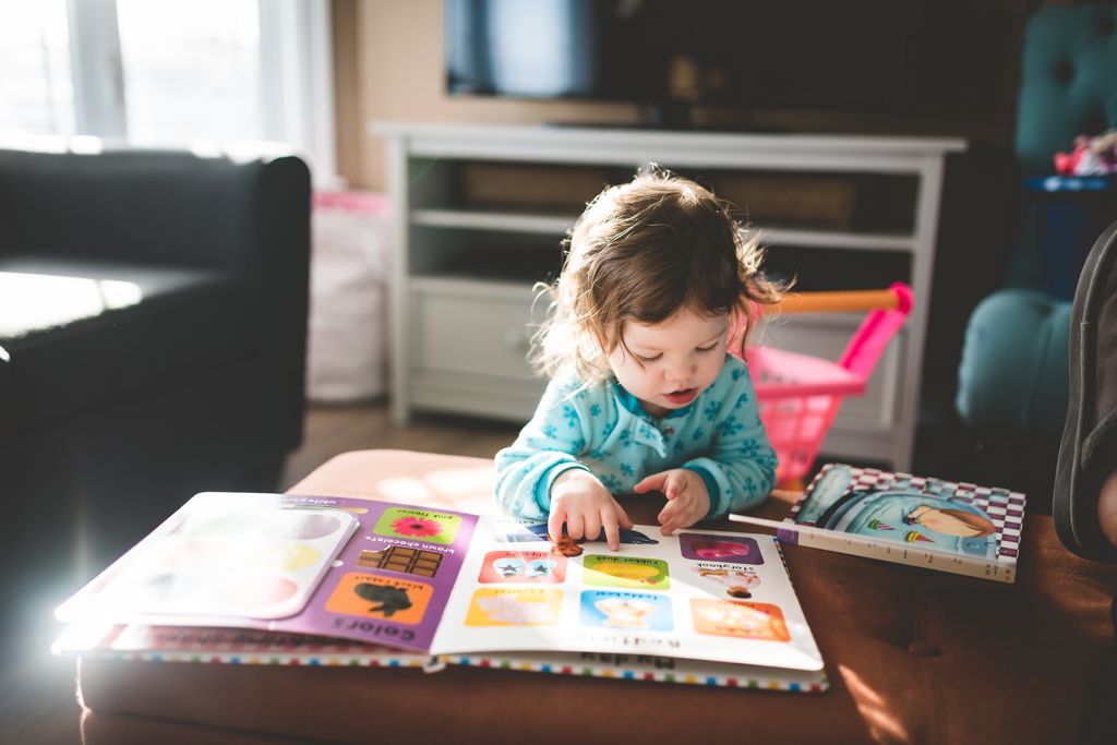 Litet barn tittar i en bilderbok.