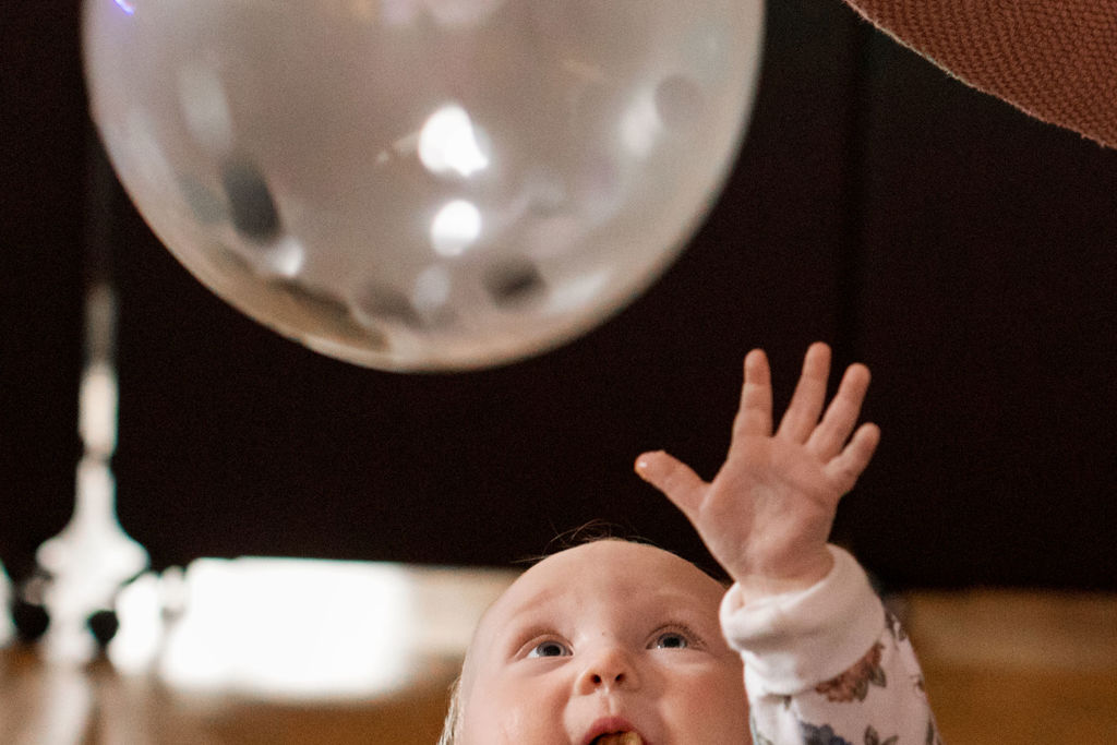 Bebis sträcker sig efter en ballong.